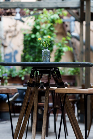 Tables in cozy european street cafe with flowersの写真素材
