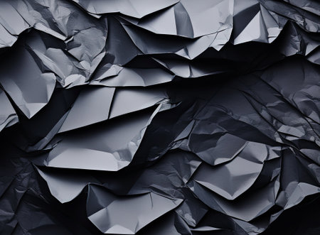 Texture of black crumpled paper. Dark paper background with bends. A sheet of wrinkled paperの素材