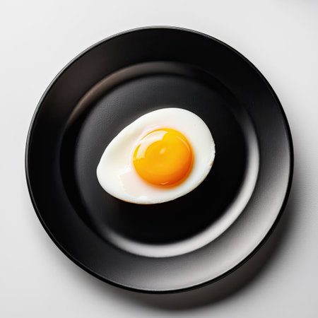 fried egg on black plate, top view. healthy and nutritious breakfast foodの素材