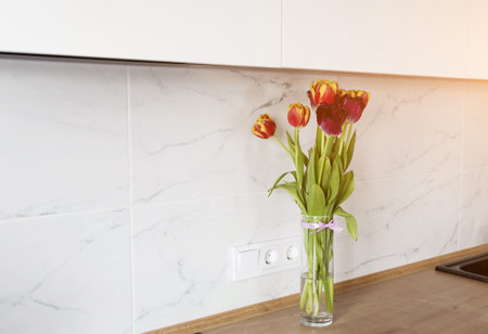 bouquet of tulips on a kitchen table. cozy kitchen areaの写真素材