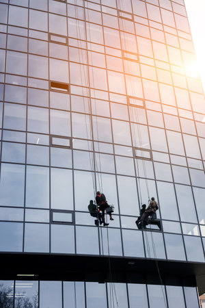 Two workers washing windows of the modern glass buildingの写真素材
