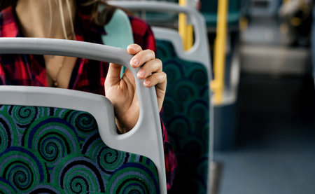 a woman rides on public transport while sitting on a seat