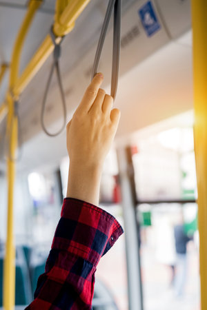 woman hand holding onto a handle of bus. Safety traveling guide and a transportationの写真素材