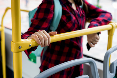 A woman's hand holds onto a handrail while driving on public transportの写真素材