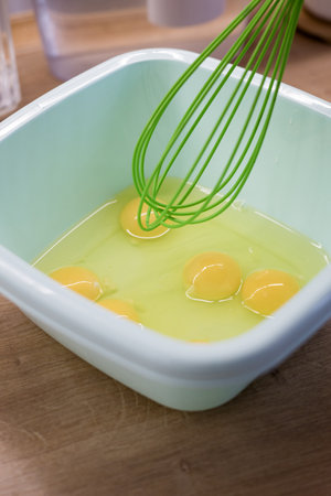 whisking eggs in white plastic bowl. cooking or baking process.の写真素材