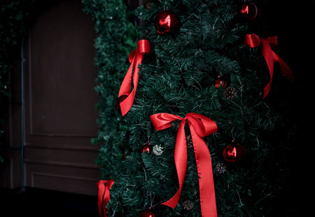 luxurious Christmas tree with elegant red bows on dark room