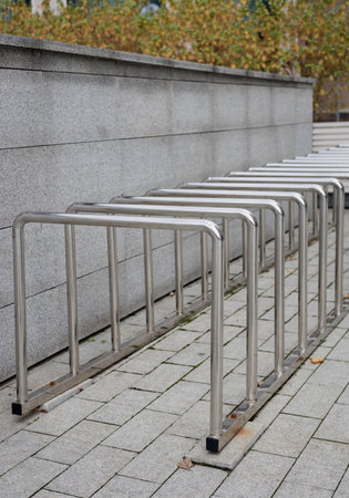 Linear arrangement of polished steel bicycle racks with urban architectural backdropの写真素材