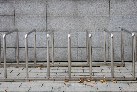 Minimalist stainless steel bicycle rack against granite wallの写真素材