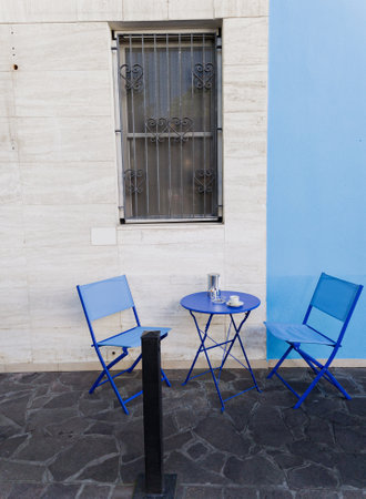 A small round blue table with two metal chairs. Outdoor terraceの写真素材