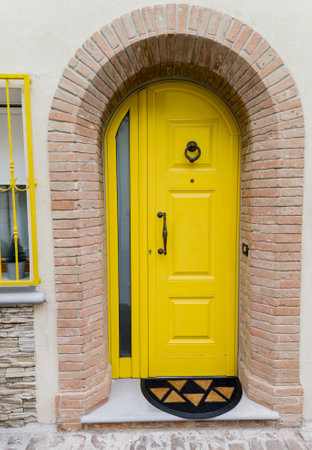 front door of a house with a bright yellow doorの写真素材