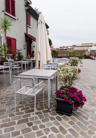 cozy tables and chairs in street cafe. Summer terrace with flowersの写真素材