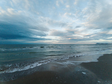 Scenic view of beautiful sea coastline with sandy beach under a cloudy skyの写真素材