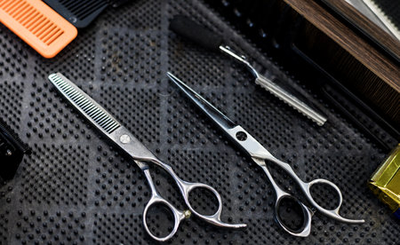 stainless professional scissors and combs on table in barbershopの写真素材