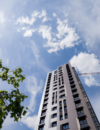Tall apartment building with windows under blue sky. structure showcases contemporary architecture...