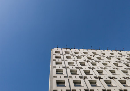 Architectural detail brutal building with many windows over blue sky