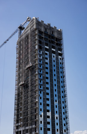 Modern Skyscraper under construction over blue sky backgroundの写真素材