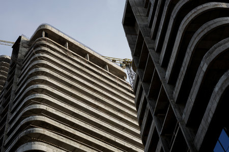 Residential multi-storey apartment building under construction. facade of a modern skyscraper in the process of glass claddingの写真素材