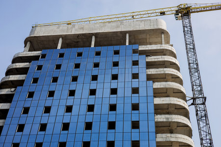 Residential multi-storey apartment building under construction. process of glazing windows, insulating the facade of a modern buildingの写真素材