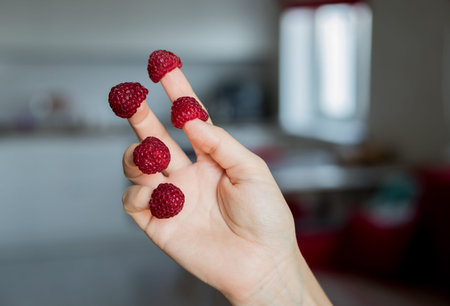 woman with raspberries on her fingers. fresh organic food