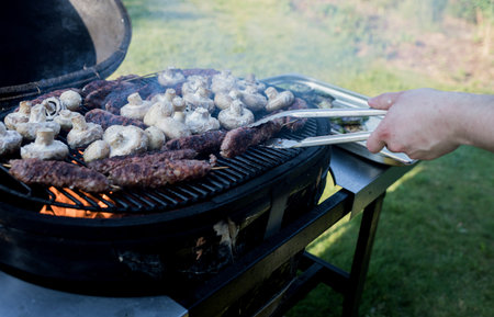 Close-up view of grilled mushrooms with meat on a grillの写真素材