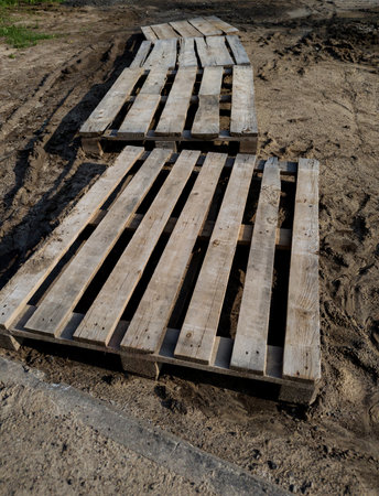 wooden pallet track in the middle of the mudの写真素材