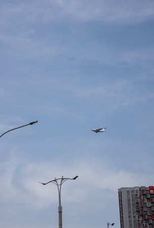 passenger plane flies low over a house or building in a residential area. The plane is on the...