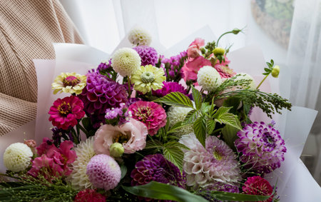 a gorgeous and bright bouquet of fresh flowers in the hands of a girlの写真素材