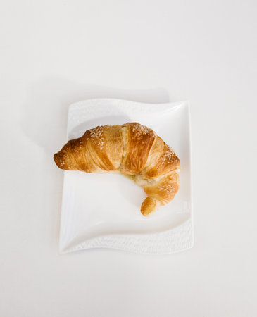 Top view of freshly baked croissant with sprinkled sugar on a white background.の写真素材