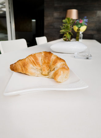 Close-up of tasty croissant, sprinkled with sugar crystals on tableの写真素材