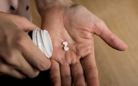 Two pills in the form of a heart lies in a female hand. medicine conceptの写真素材