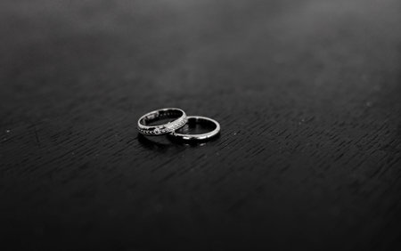 two wedding rings on wooden background, copy space. black and whiteの写真素材