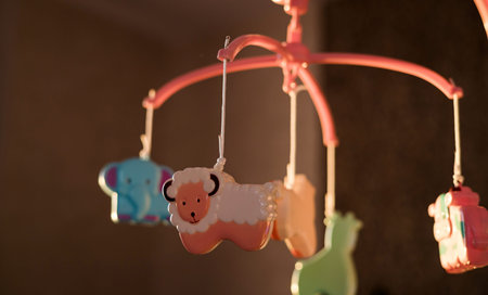 pink baby nursery mobile featuring cute hanging animal toys. warm, cozy indoor lighting atmosphere...