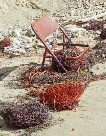 Old rusty chair left on beachの写真素材