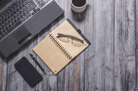 Computer, notebook, phone and office in dark backgroundの写真素材