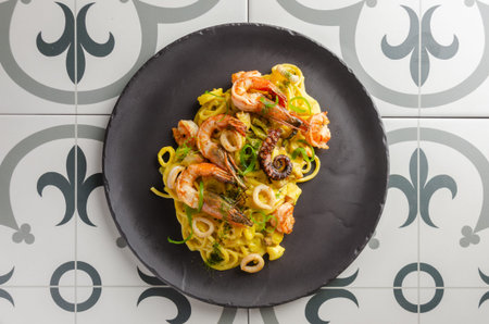 Spaghetti a la marinara served on a black plate on a decorated background. Flat Layの写真素材