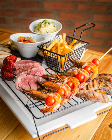 Grill of meat, chorizo, chicken accompanied by French fries. Accompanied by coleslaw and chimichurriの写真素材