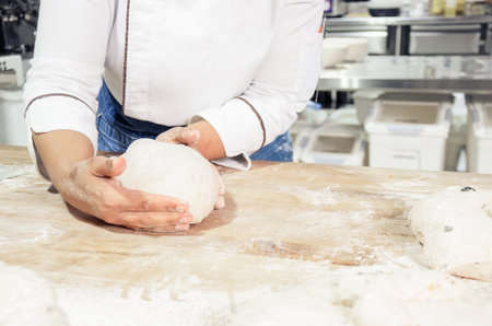 Kneading and preparation of sourdough-based bread. On a wooden table. in bakery
