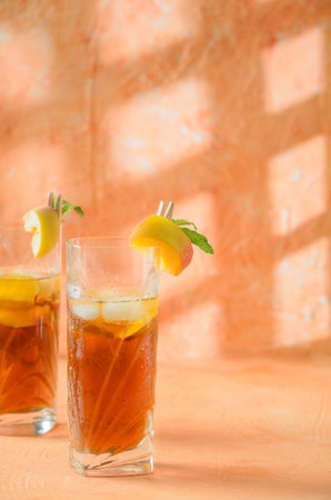peach iced tea Jug in the background. Shadows on a melon-colored background.の写真素材