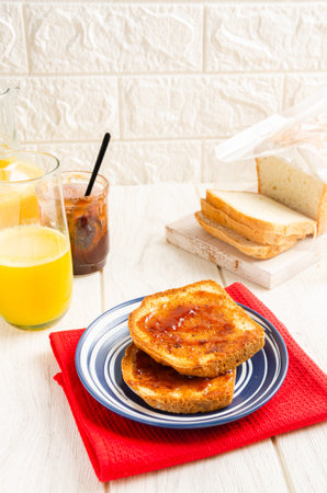 Toast with jam and orange juice. White background.
