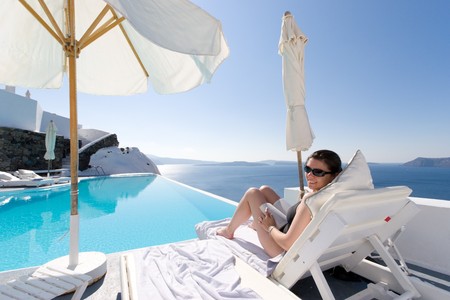 Woman sitting near pool in Santorini, Greeceの写真素材