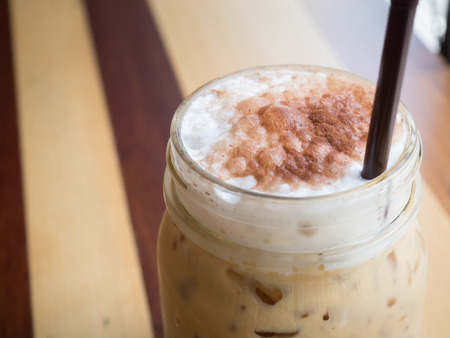 cocoa power on the milk foam in a glass of iced cappucinoの写真素材