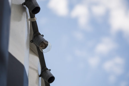 Light Bulb hangs on the string on top of container box with sky for the background