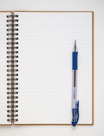 A blank lined notebook with blue pen on white backgroundの写真素材
