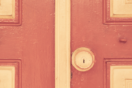 Old circle door handle on red wall in vintage toneの写真素材