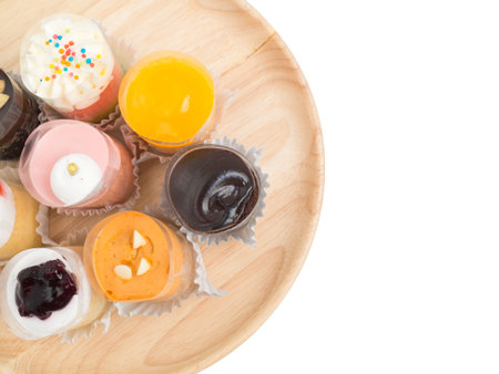 Colorful different kind of small cup cakes on wooden tray