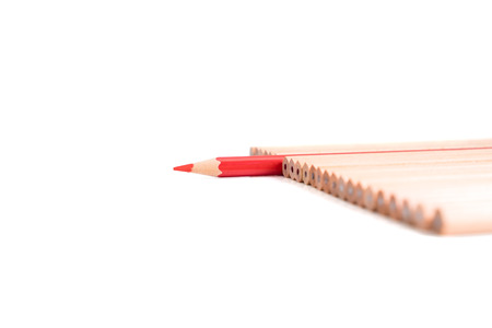Red colored pencil stand out of other brown pencils - business concept of leader, success, unique- isolated object on white backgroundの写真素材