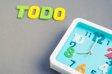 Selective focus on modern aqua blue square clock at 8 o'clock with todo wording in the background - eight o'clock on gray background - concept of time to workの写真素材
