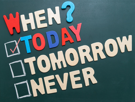 Business time management concept - When? Today, Tomorrow, or Never with checkboxes and red marking on blackboardの写真素材