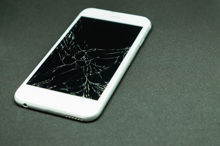 Selective focus on cracked mobile phone screen on black backgroundの写真素材