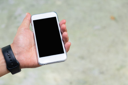 A man hold white mobile phone in his left hand